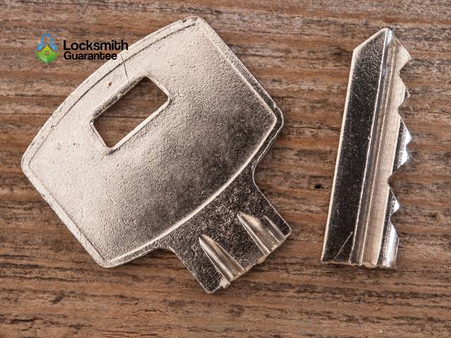 Two halves of a snapped house key beside the replacement cut from them