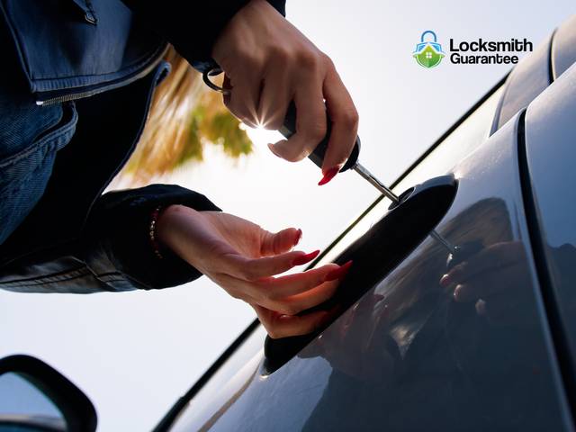 Locksmith working on the door lock of a parked car