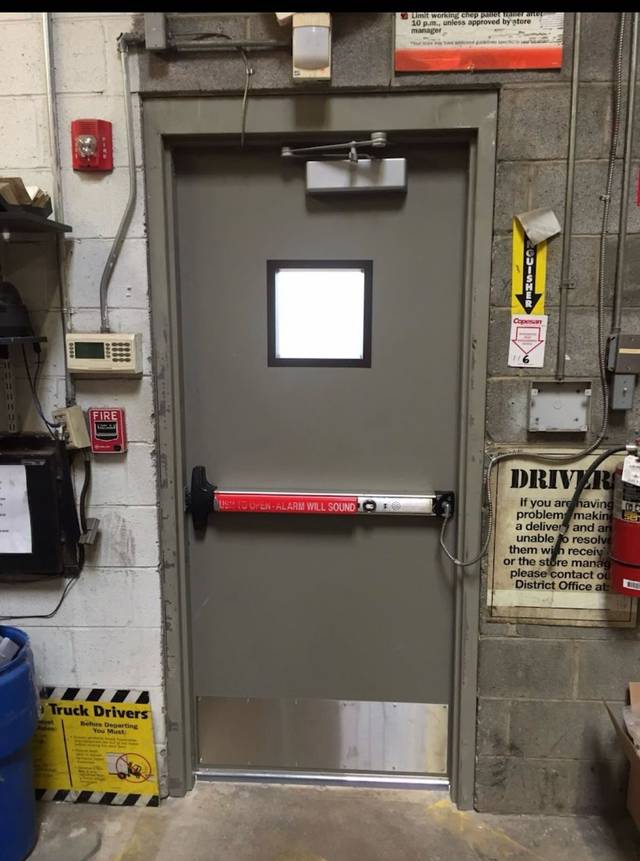 Alarmed push bar fitted across a commercial exit door