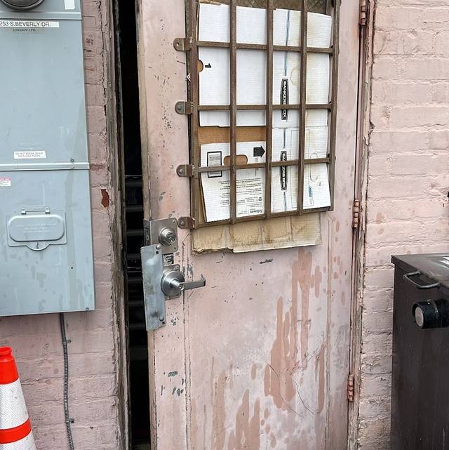 Latch guard plate screwed over the gap at a commercial door edge