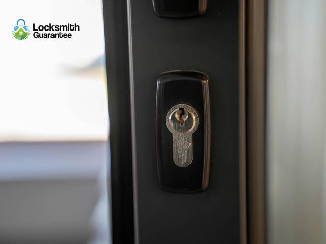 Lever handle and cylinder being fitted to an office door