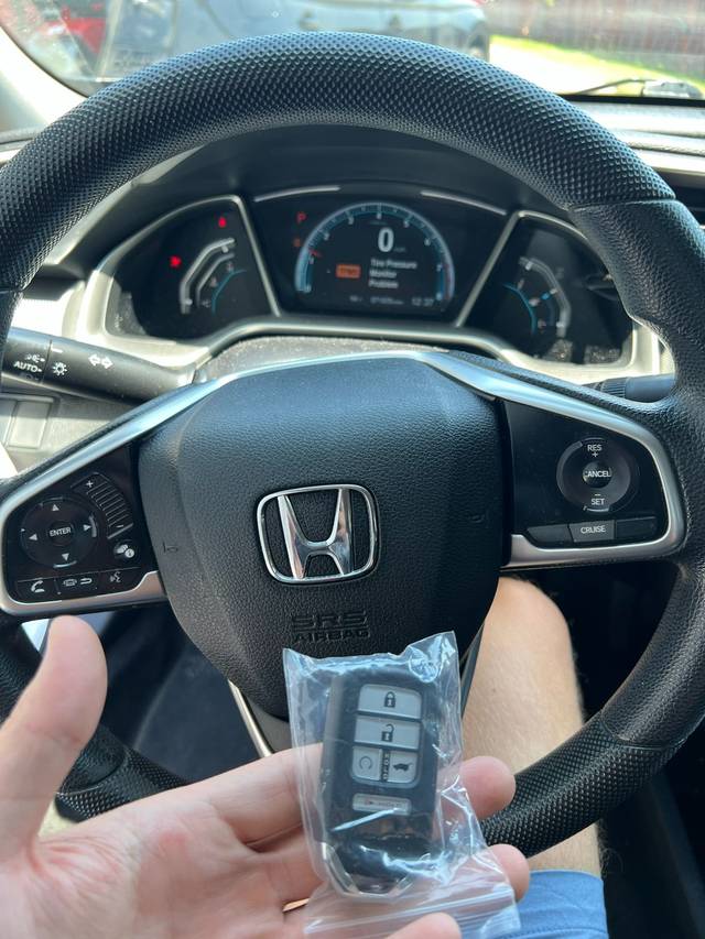 Replacement Honda key fob beside the worn original