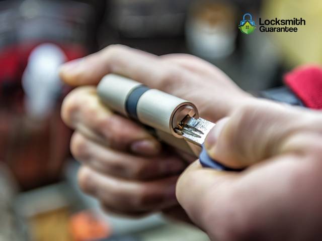 Locksmith working a cylinder by headlamp on an unlit porch
