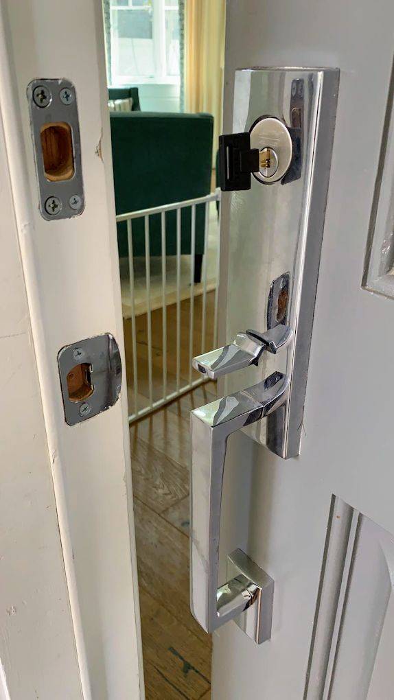 Chrome handle set and deadbolt on a modern front door