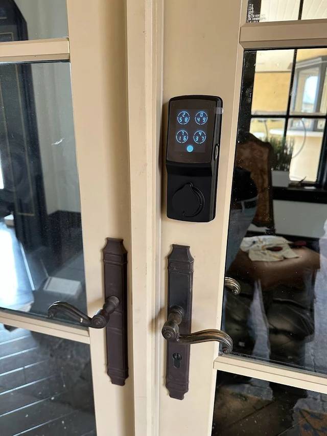 Touchscreen keypad lock lit up on a front door